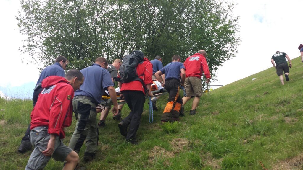 A joint group of Bolton MRT and Rossendale & Pendle MRT team members carries the injured male to the Helimed aircraft